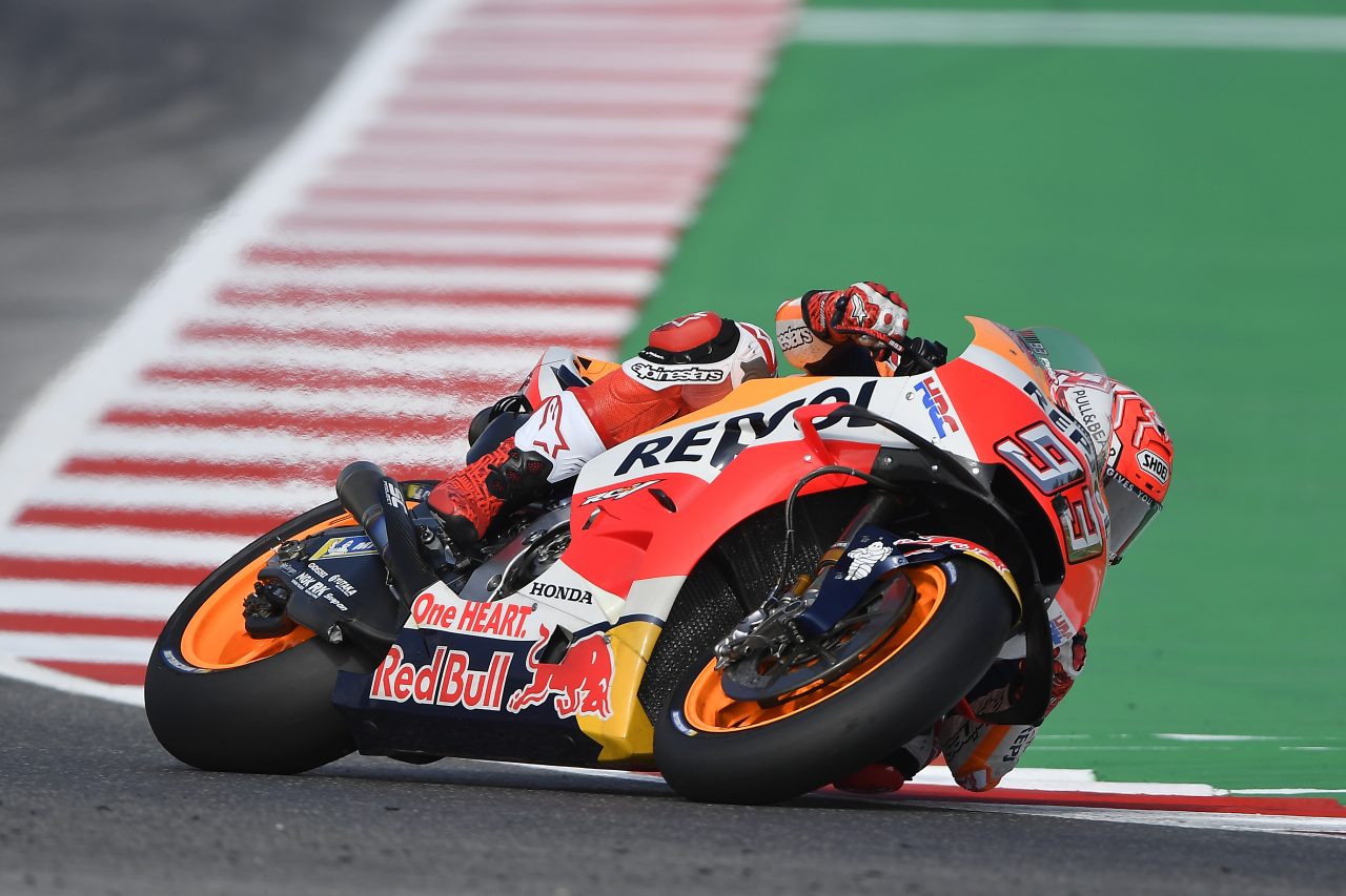 Piloto da Honda motos fazendo curva quase deitado no MotoGP