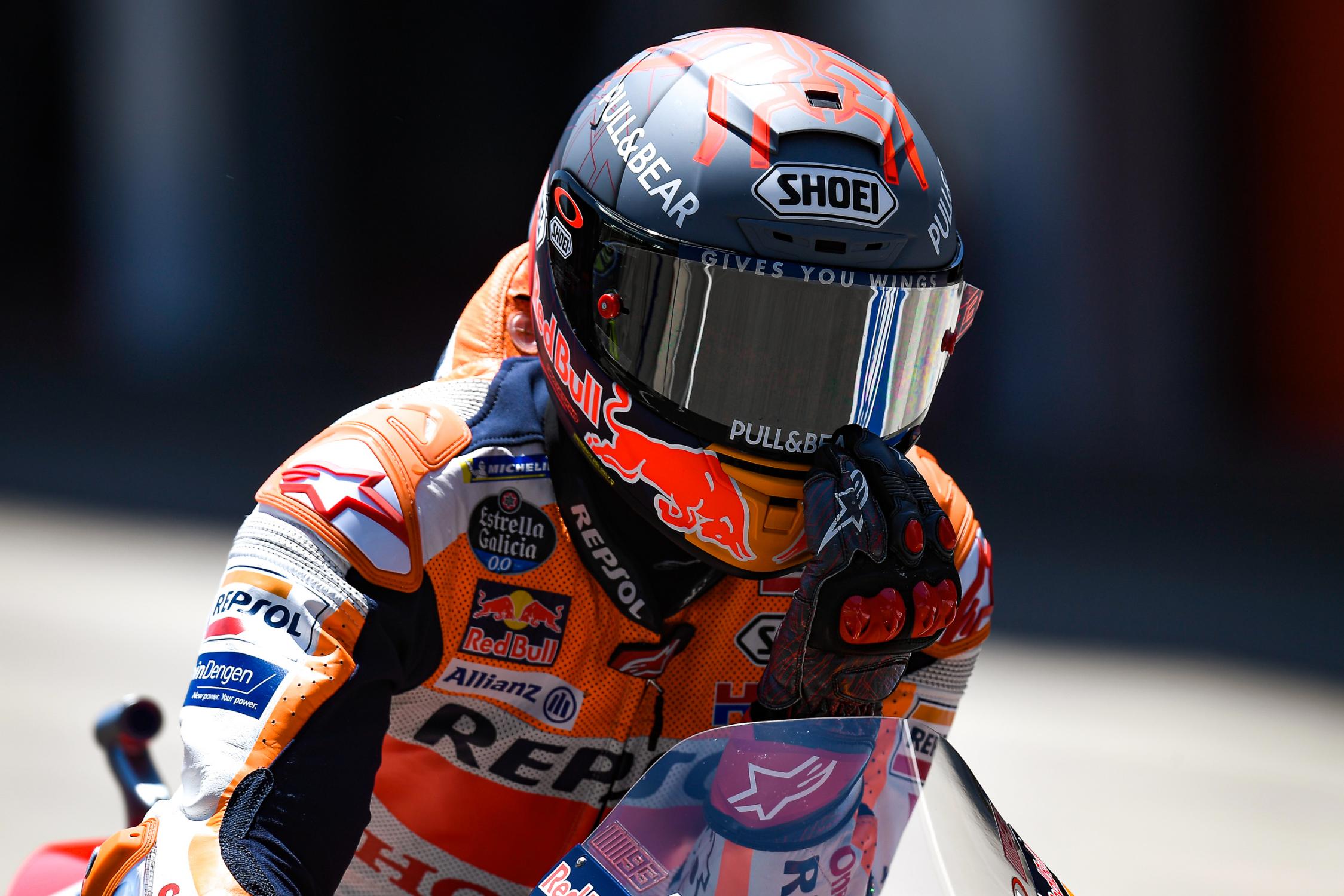 Marc Marquez em sua moto arrumando o capacete 