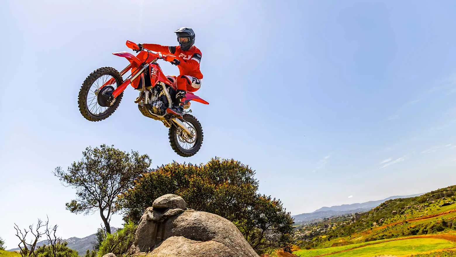 Piloto saltando com a Moto Honda CRF 250 em cenáro off road