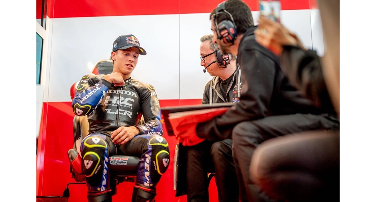Piloto da Honda conversa com dois membros da equipe 